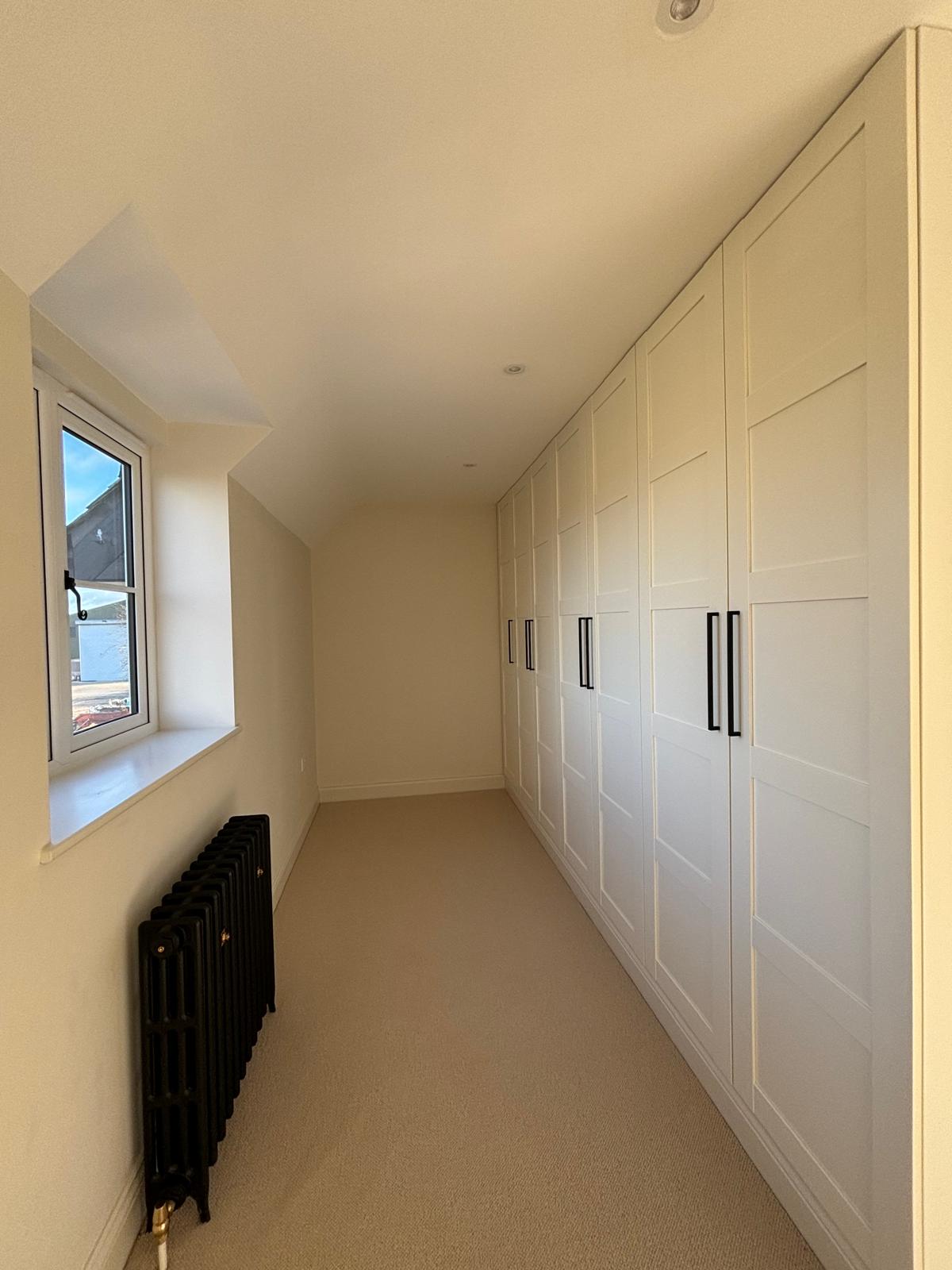 Clean white fitted wardrobes in carpeted bedroom hallway Faringdon