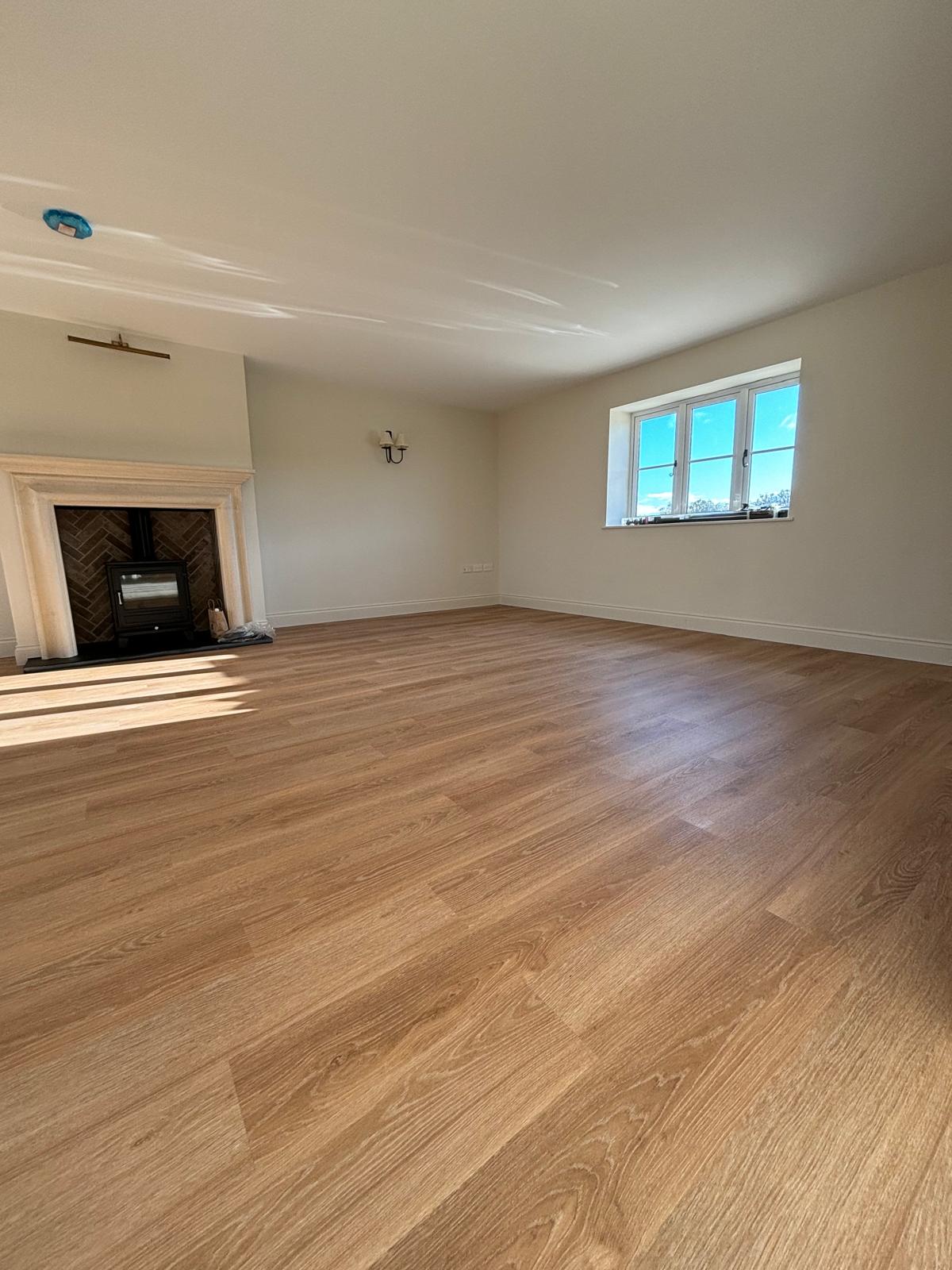 Hardwood floor living room with fireplace after builder's cleaning